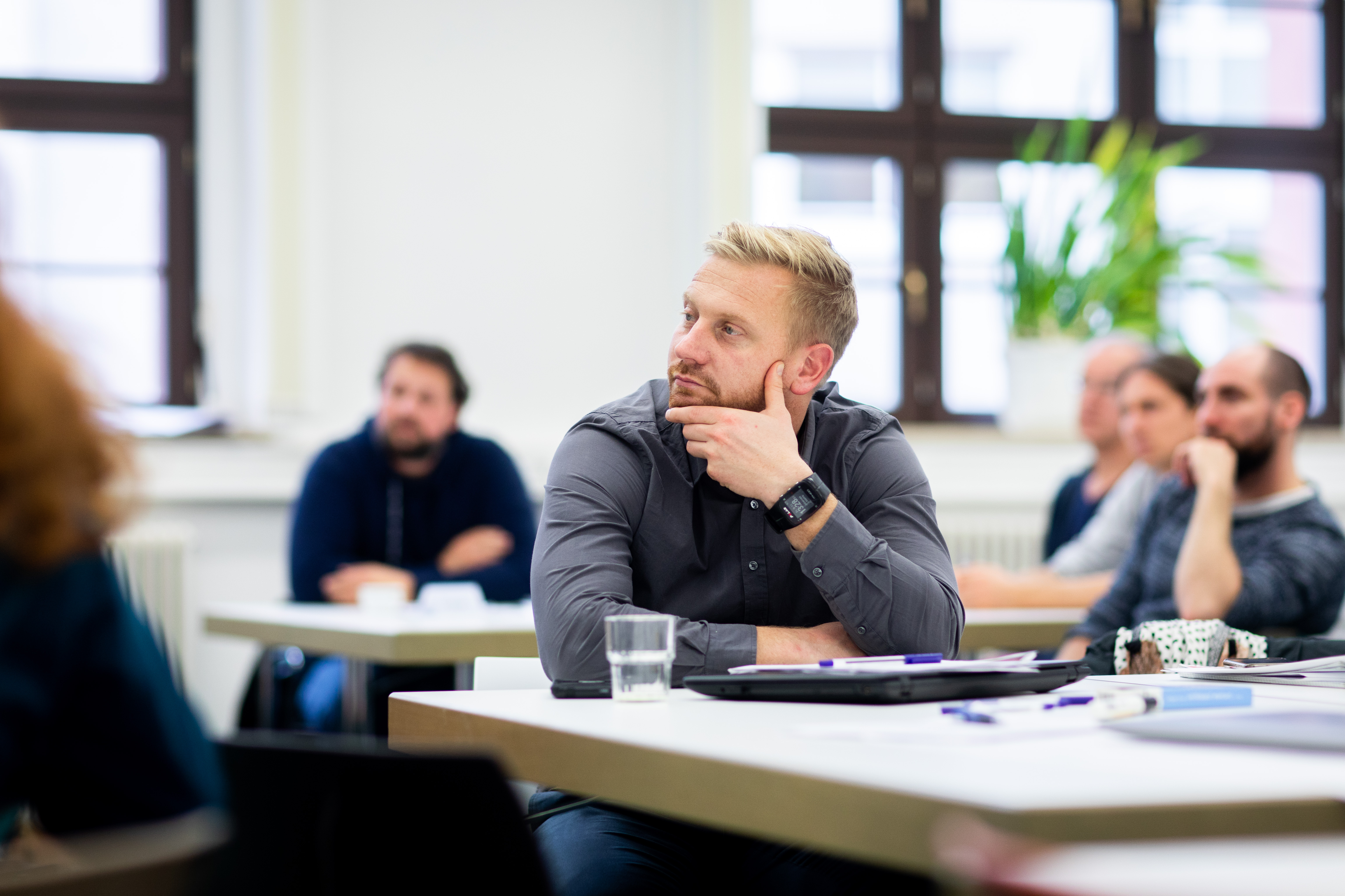 Studierende sitzen an Tischen