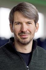 Portrait of a smiling man with brown hair and beard