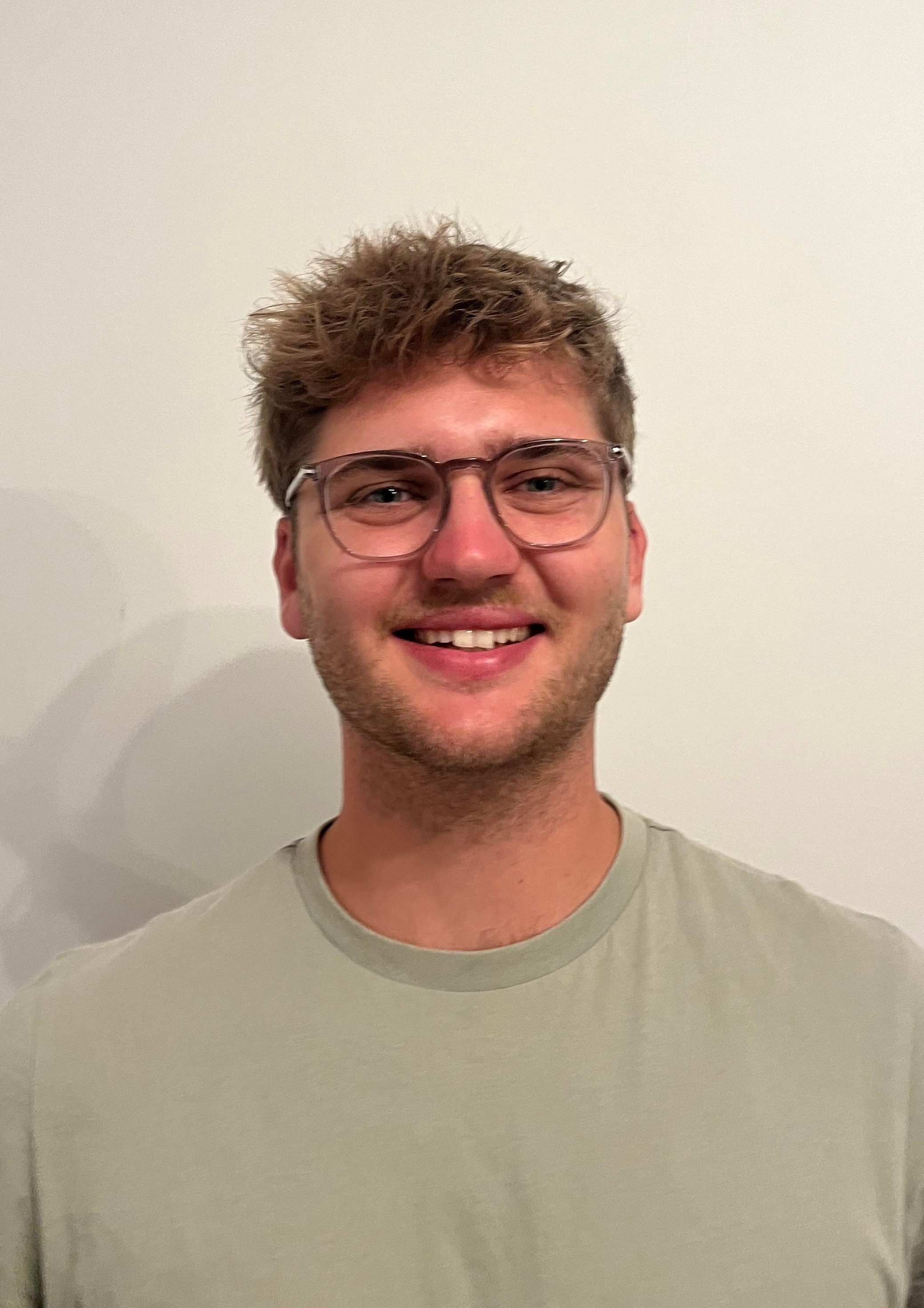 Ein mann in einer blauen jacke mit kapuze steht vor einem fluss