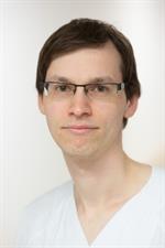 Ein mann mit brille und weißem hemd blickt in die kamera