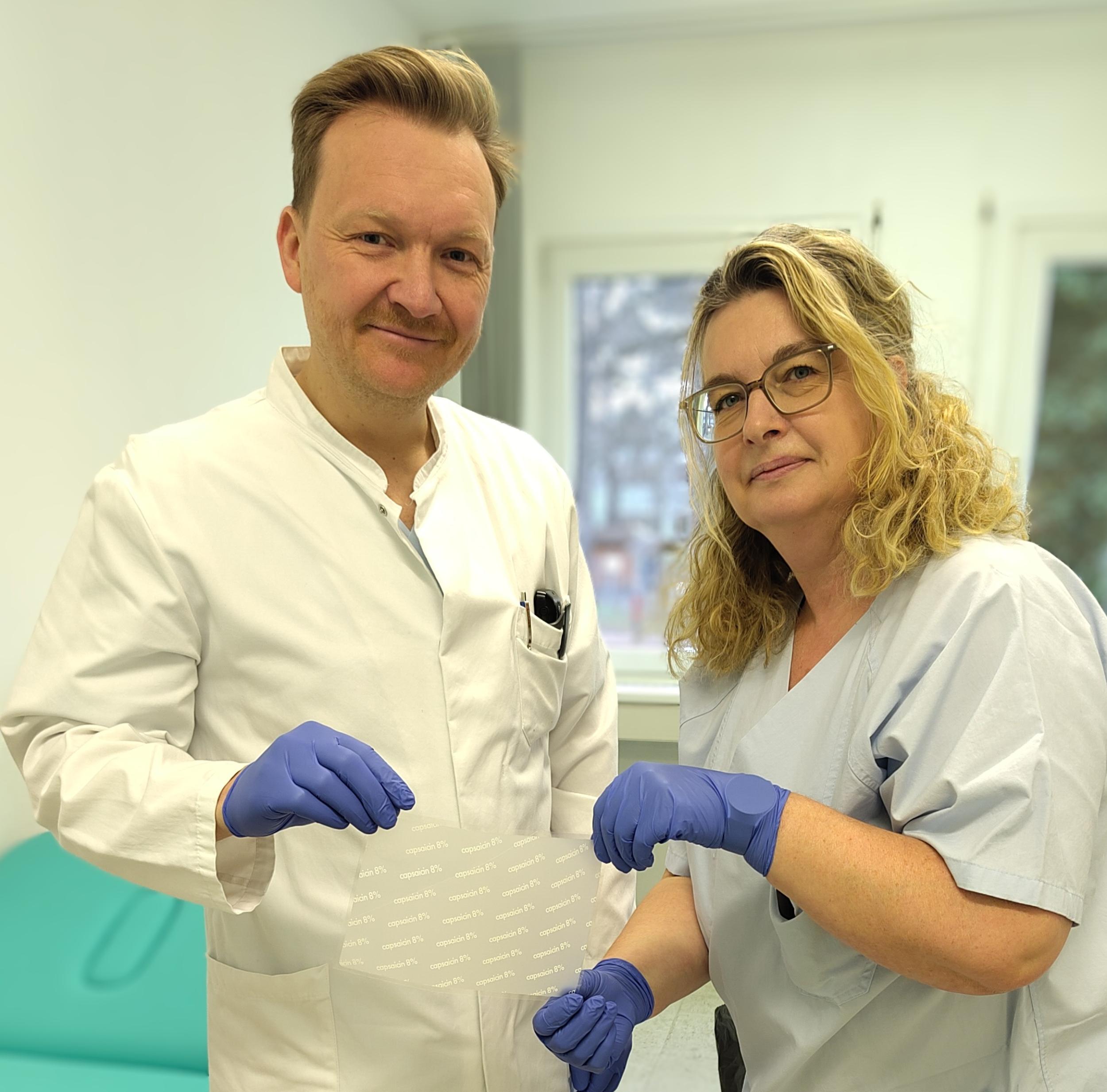 Dr. Stefan Scheike und Manuela Boldt, Gesundheits- und Krankenpflegerin, zeigen das Pflaster, mit dem der Chiliwirkstoff bei Schmerzpatienten eingesetzt wird.