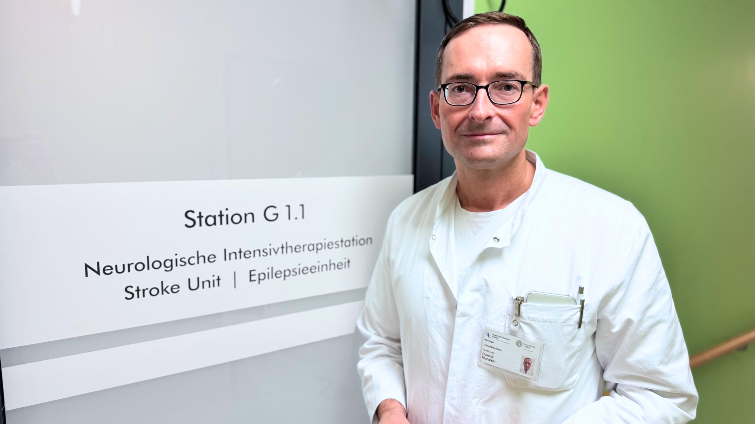Prof. Dr. Dominik Michalski vor dem Eingang zur Stroke Unit. Auf dieser Spezialstation werden Schlaganfallpatientinnen und -patienten bestmöglich versorgt.