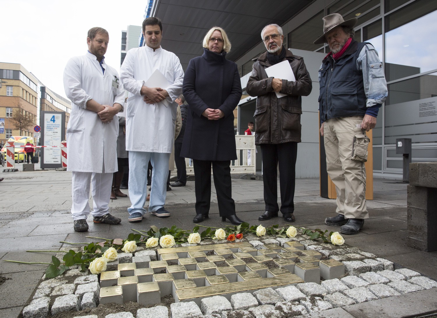 Im Gedenken an die 36 ehemaligen jüdischen Mitglieder der Deutschen Gesellschaft für Unfallchirurgie, an die nun vor dem Haupteingang des UKL Stolpersteine erinnern: Marya Verdel (Mitte) und Prof. Wolfgang E. Fleig (2.v.r.) vom Vorstand des UKL,  Oberarzt Dr. Jan Dirk Theopold (li.), Dr. Orkun Özkurtul (2.v.li.) sowie Stolperstein-Initiator Gunter Demnig (re.).