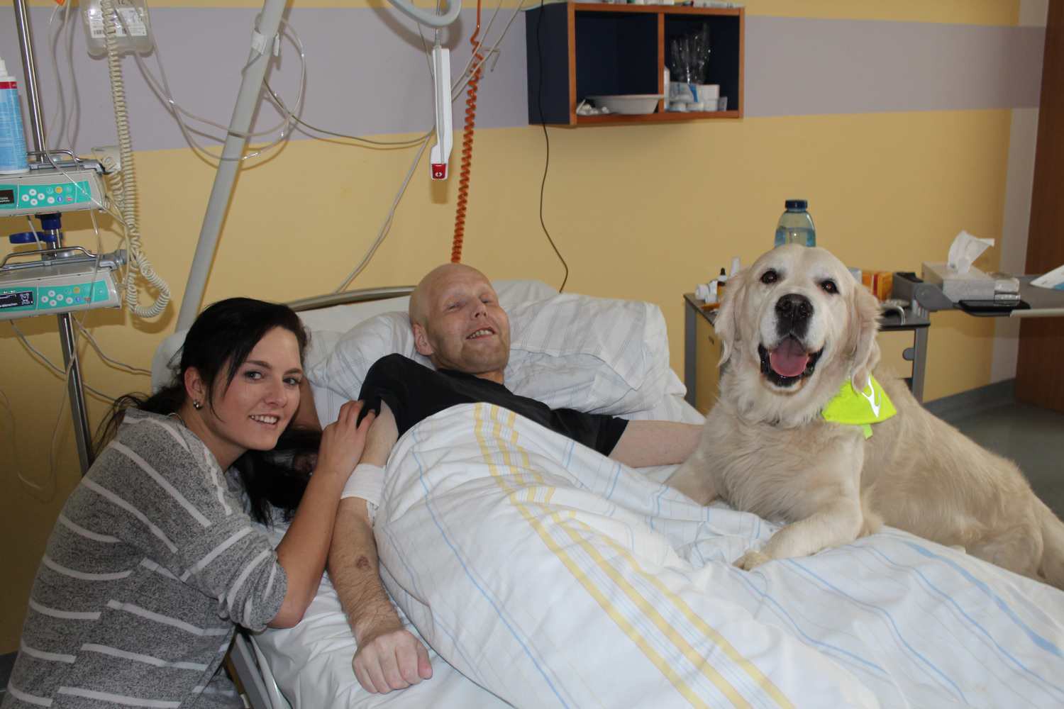 Zusammen mit seiner Halterin Daniela Trambowsky (li.) besucht Therapiehund Sunny schwerkranke Patienten der Palliativstation des UKL auf ihren Zimmern und sorgt für Momente der Freude. Der Patient auf diesem Foto ist in der Zwischenzeit leider bereits verstorben.