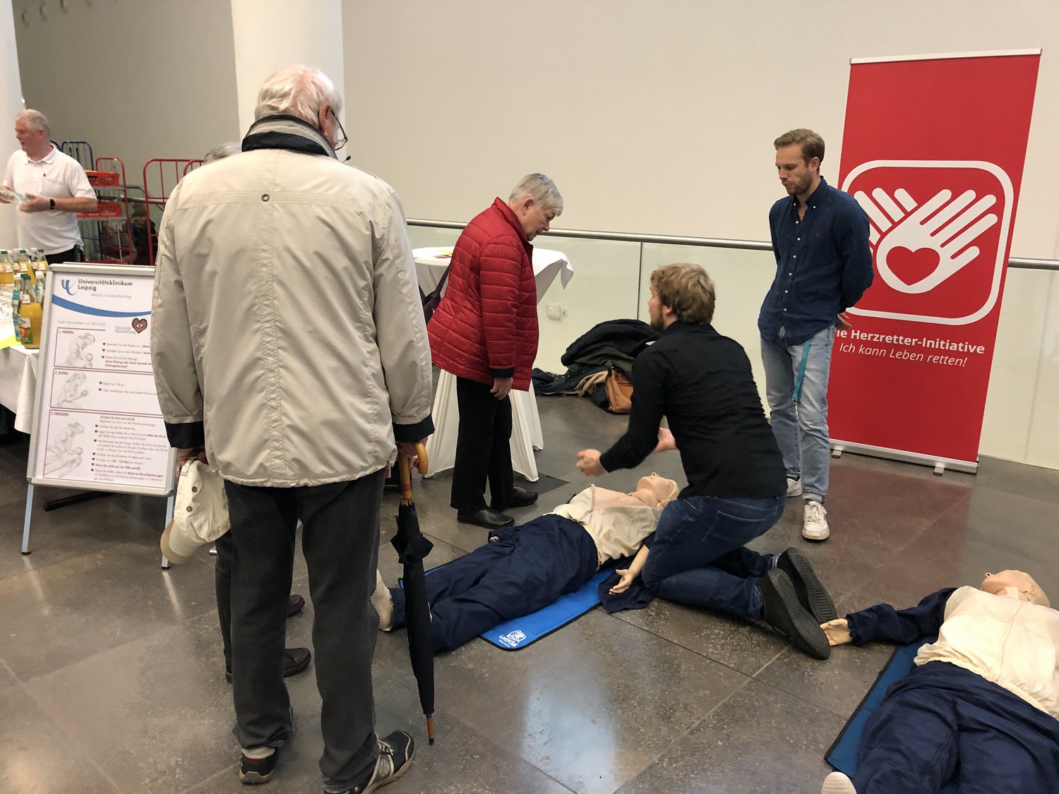 Die UKL-Mitarbeiter Dr. Paul Baum (kniend) und Joshua Kandels stellen auf der Veranstaltung zum plötzlichen Herztod Anfang November im Paulinum der Universität Leipzig die Herzretter-Initiative vor und erläutern den Besuchern Wiederbelebungs-Maßnahmen.