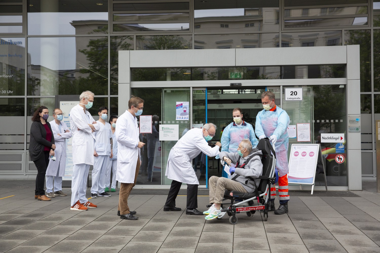 Mit einem sehr herzlichen „Grazie“ verabschiedete sich Felice Perani (sitzend) von UKL-Vorstand Prof. Christoph Josten (beim Ellenbogengruß) sowie seinen Ärzten Prof. Sebastian Stehr (vorn, Mitte) Dr. Sven Laudi (3.v.l.) und Prof. Sven Bercker (hinten, 2.v.l.). Der 57-Jährige aus dem italienischen Bergamo ist von der Lungenkrankheit Covid-19 genesen und begibt sich nun in eine Reha-Klinik nahe Leipzig. Er war einer der beiden ersten italienischen Patienten, die zur Behandlung nach Deutschland gebracht wurden.