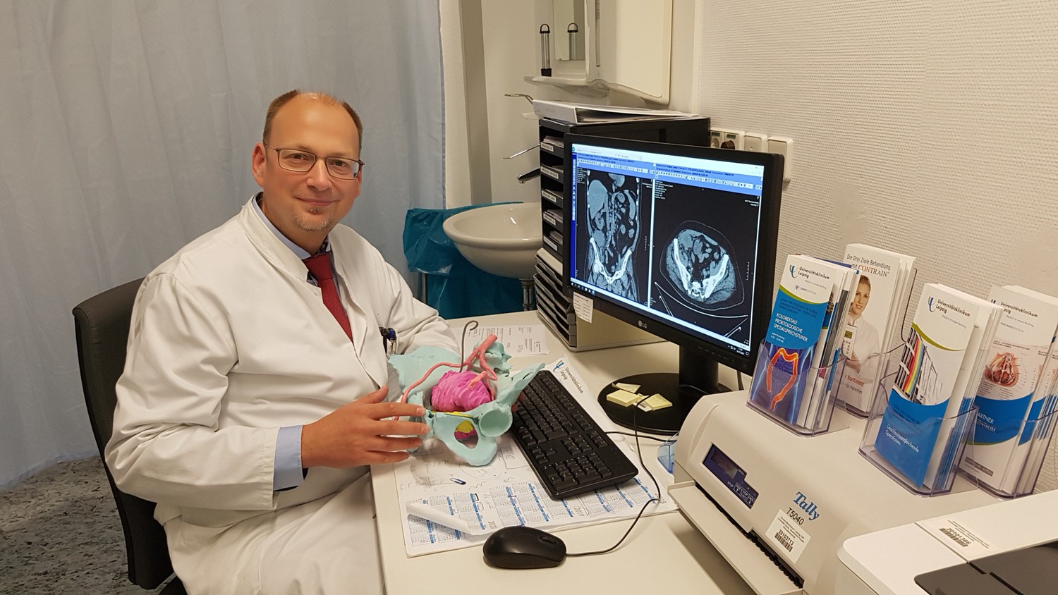 Privatdozent Dr. Boris Jansen-Winkeln, Stellvertretender Leiter des Bereichs Viszeralchirurgie am UKL, mit dem Modell eines Beckens mit dem Rezidivtumor (pink eingefärbt).
