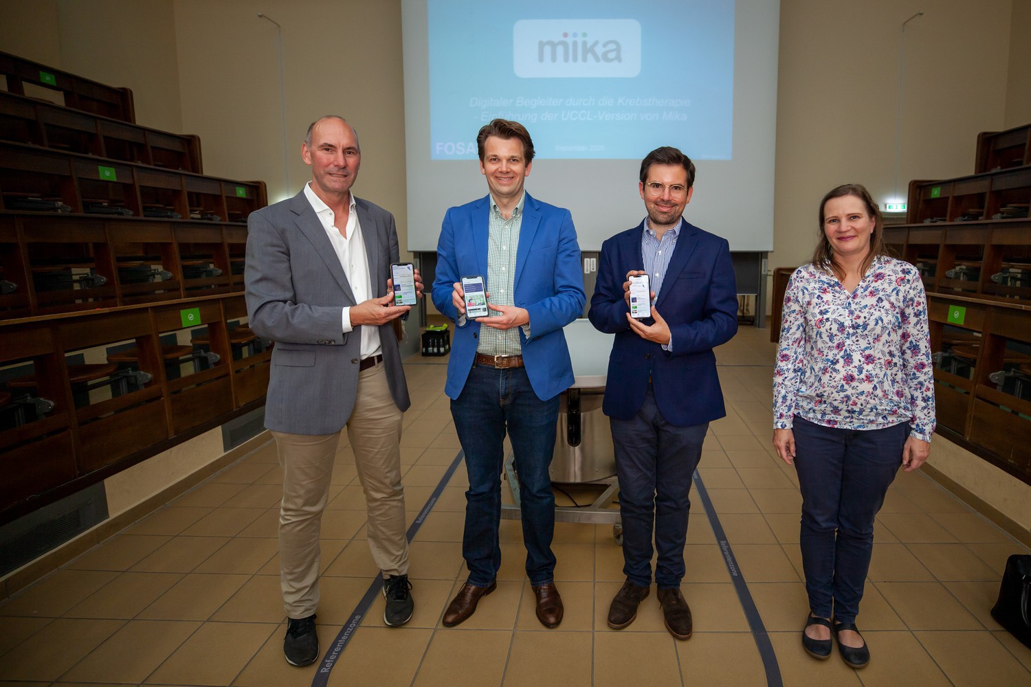 Prof. Florian Lordick, Direktor des Universitären Krebszentrums Leipzig (UCCL), Dr. Jan Simon Raue, Geschäftsführer Fosanis GmbH, Rouwen Hirth, Key Account Manager Fosanis, und Dr. Yvonne Haffner (v.l.n.r.), Leiterin Klinische Forschung am UCCL, bei der Vorstellung der App im Anatomie-Hörsaal der Medizinischen Fakultät der Uni Leipzig an der Liebigstraße.