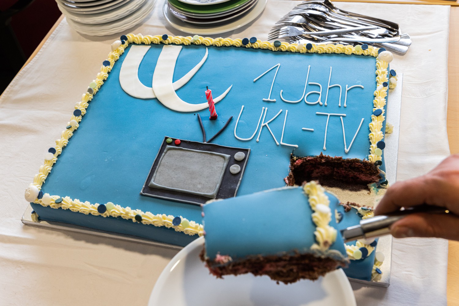 Zur Feier des Tages für ein nicht alltägliches Projekt – die erfolgreiche Etablierung eines eigenen Fernsehkanals für das Klinikum – sollte es zum ersten Geburtstag auch ein außergewöhnliches Präsent sein: die UKL-TV-Torte.