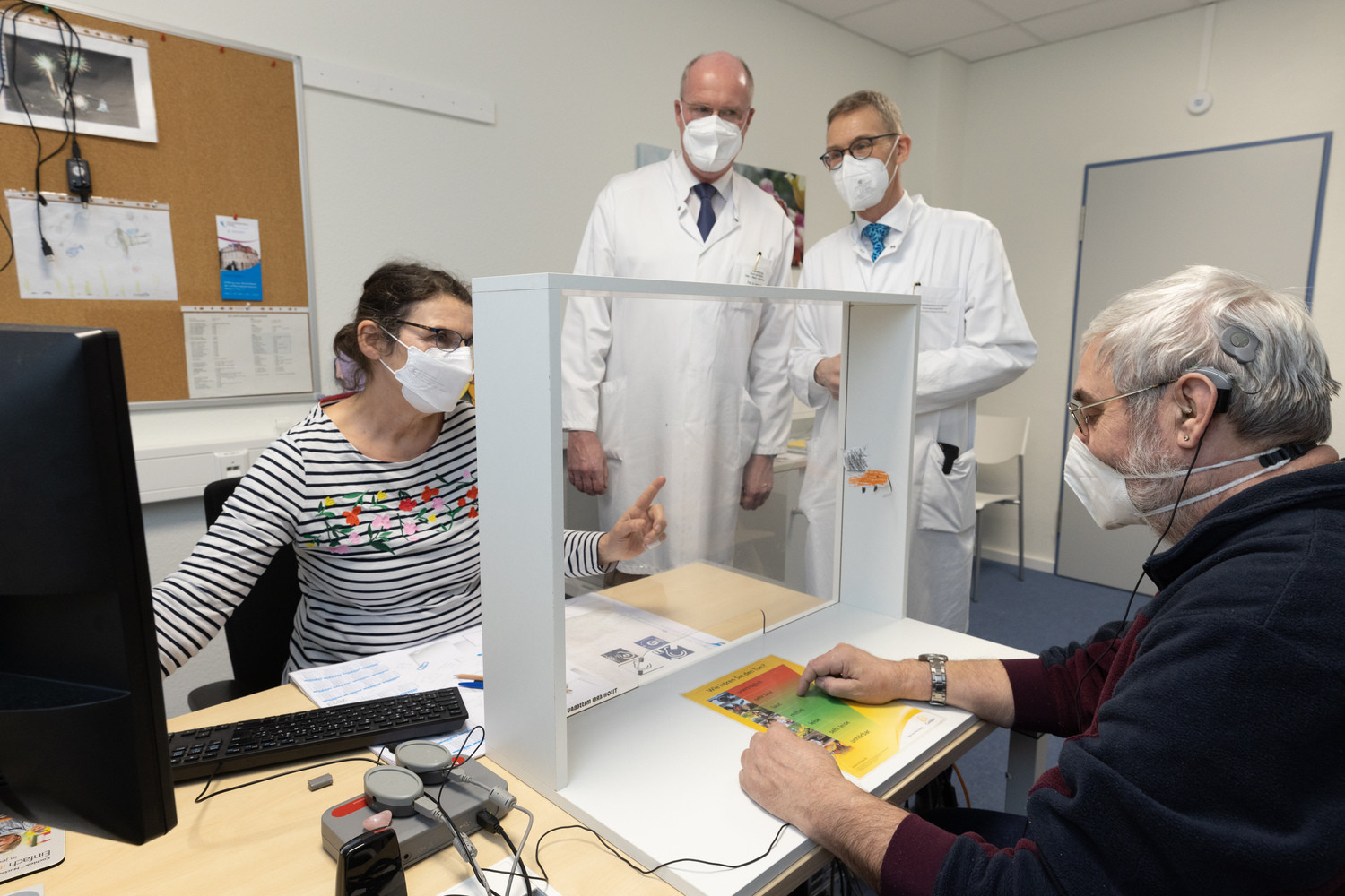 Die neuen Räume werden bereits aktiv genutzt: Prof. Michael Fuchs (2.v.r.), CI-Zentrumsleiter, und HNO-Klinikdirektor Prof. Andreas Dietz (2.v.l.) schauen während der offiziellen Eröffnung bei Audiologieassistentin Christiane Kühn (li.) vorbei, die bei Hans-Jochen Pein (re.) eine technische Anpassung an dessen CI-Modul, zu erkennen in und über dem linken Ohr, vornimmt.