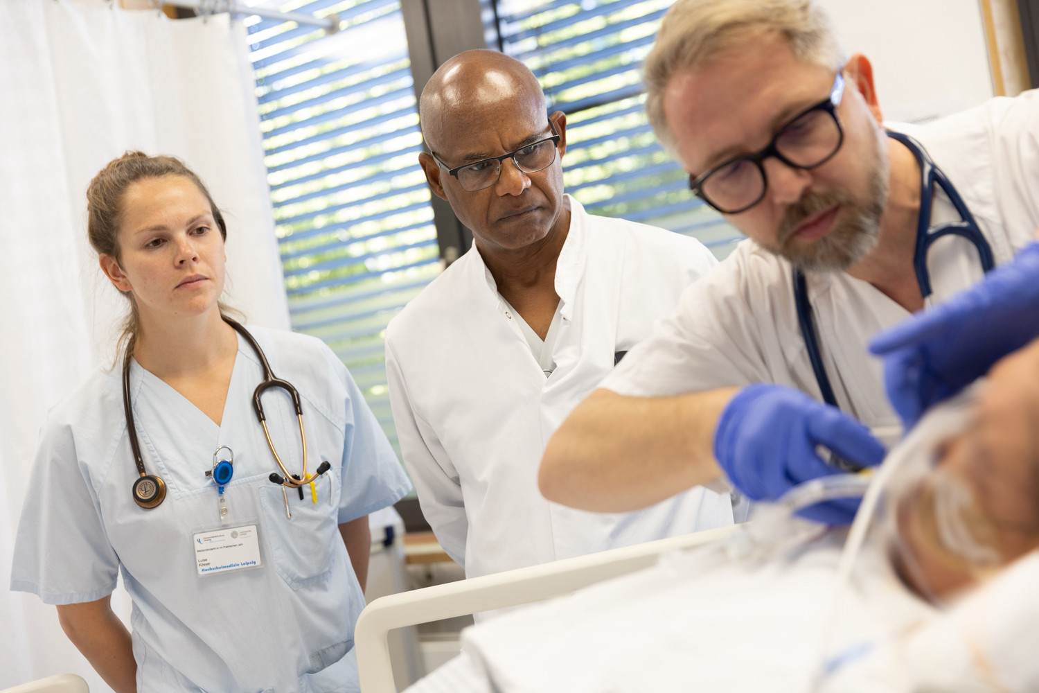 Prof. Sirak Petros (Mi.) verfolgt, ebenso wie die Medizinstudentin im Praktischen Jahr Luise Kösser (li.), die Behandlung eines Intensivpatienten durch Dr. Sven Fikenzer (re.). Im Interview spricht Prof. Petros unter anderem über die Folgen einer Wiederbelebung auf den Organismus.