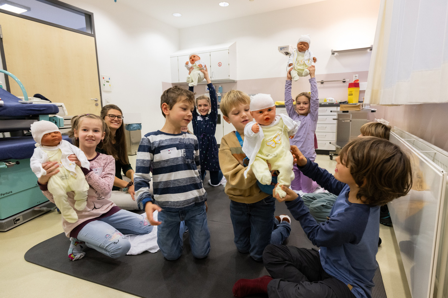 Sichtliches Vergnügen bereitete diesen Mädchen und Jungen beim ersten UKL-„Kindermitbringtag“ der Besuch der Abteilung für Geburtsmedizin. Unter fachkundiger Anleitung probierten sie sich unter anderem im Anziehen und Wickeln dieser Baby-Puppen.
