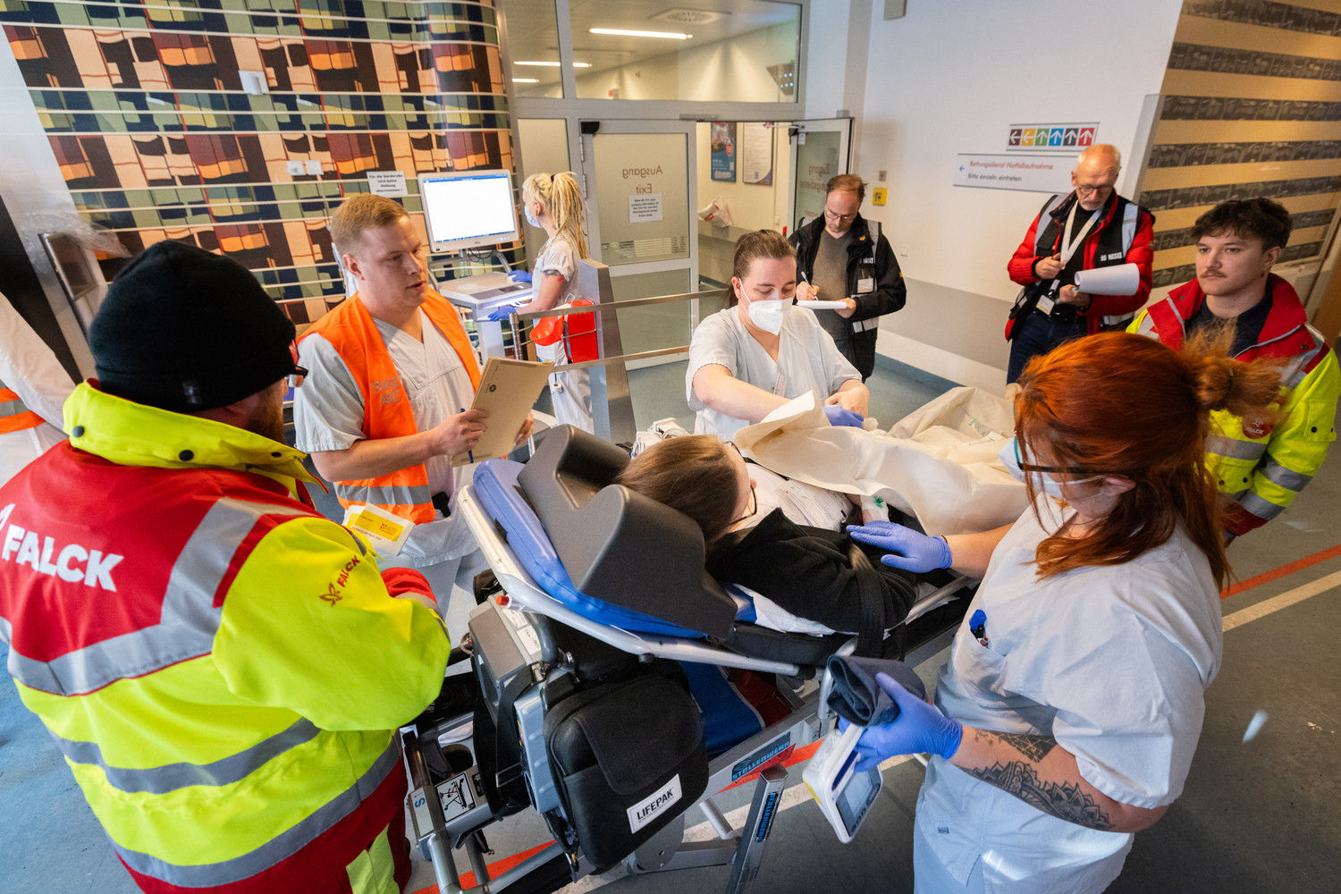 Zum Glück nur eine Übung: Nach einem angeblichen Unfall mit zwei Bussen werden professionell geschminkte Darsteller:innen als „Verletzte“ in die Zentrale Notfallaufnahme des UKL gebracht. Auf dem Foto schaut sich der Triage-Arzt (2.v.l.) eine „Patientin“ an und entscheidet je nach Schwere und Art der Verletzung über die entsprechende Weiterbehandlung. Pflegende versorgen die „verletzte“ Person, und im Hintergrund beobachten zwei Experten der ASB-Gruppe aus Berlin den Vorgang, um ihn später in ihre Auswertung einfließen zu lassen.